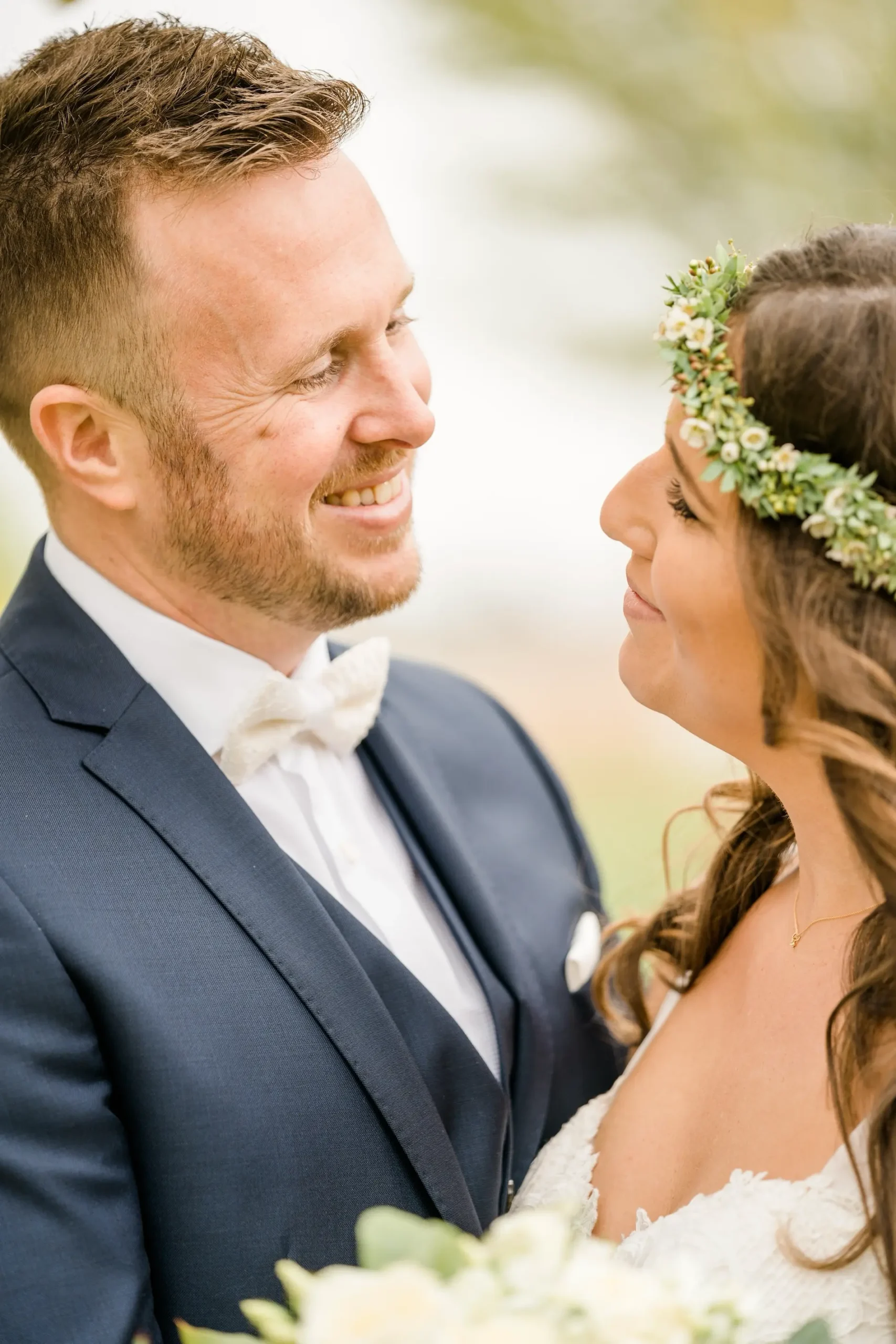 Hochzeitspaar schaut sich lächelnd in die Augen, die Braut trägt einen Brautstrauß
